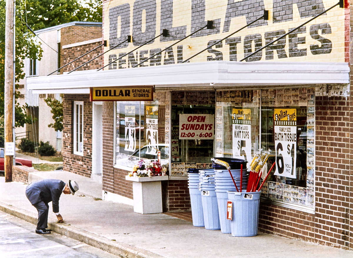 Cal Turner, Sr. picks a weed in front of Scottsville, KY's Dollar General store.