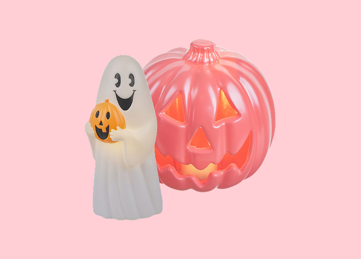 Halloween décor featuring a ghost holding a jack-o'-lantern and a glowing pumpkin decoration